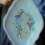 Assiette en faience ovale avec un decor qui représente 3 oiseaux entourés de fleurs