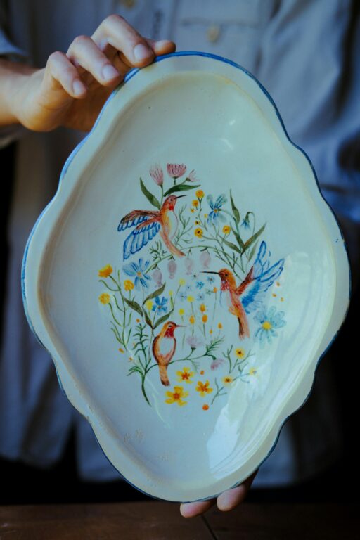 Assiette en faience ovale avec un decor qui représente 3 oiseaux entourés de fleurs